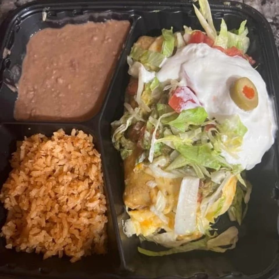 Dos Pesos Mexican Restaurant's to-go meal with rice, refried beans, and a burrito topped with sour cream and olive.
